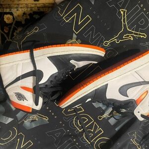 Youth Air Jordan Black, And White High Top Sneakers With Bright Orange Accents